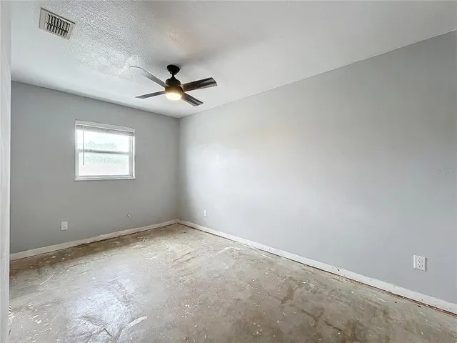 a view of a yard in front of a house with a large tree