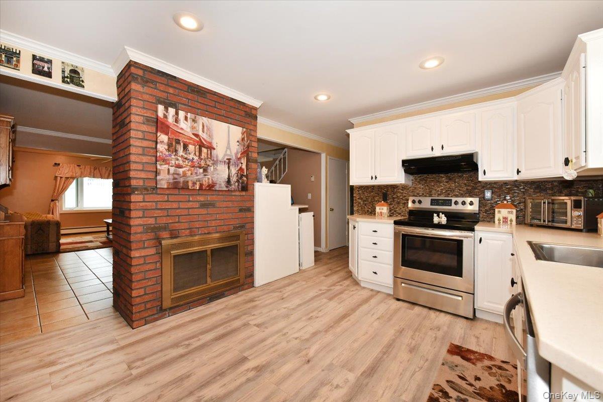 307 Blacksmith Road Levittown, NY 11756 - Photo 12 of 27 a kitchen with granite countertop a stove top oven a sink and a microwave