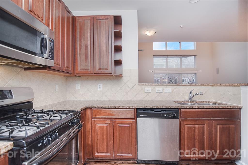 610 Raphael Place Charlotte, NC 28205 - Photo 7 of 27 a kitchen with wooden cabinets and a stove top oven