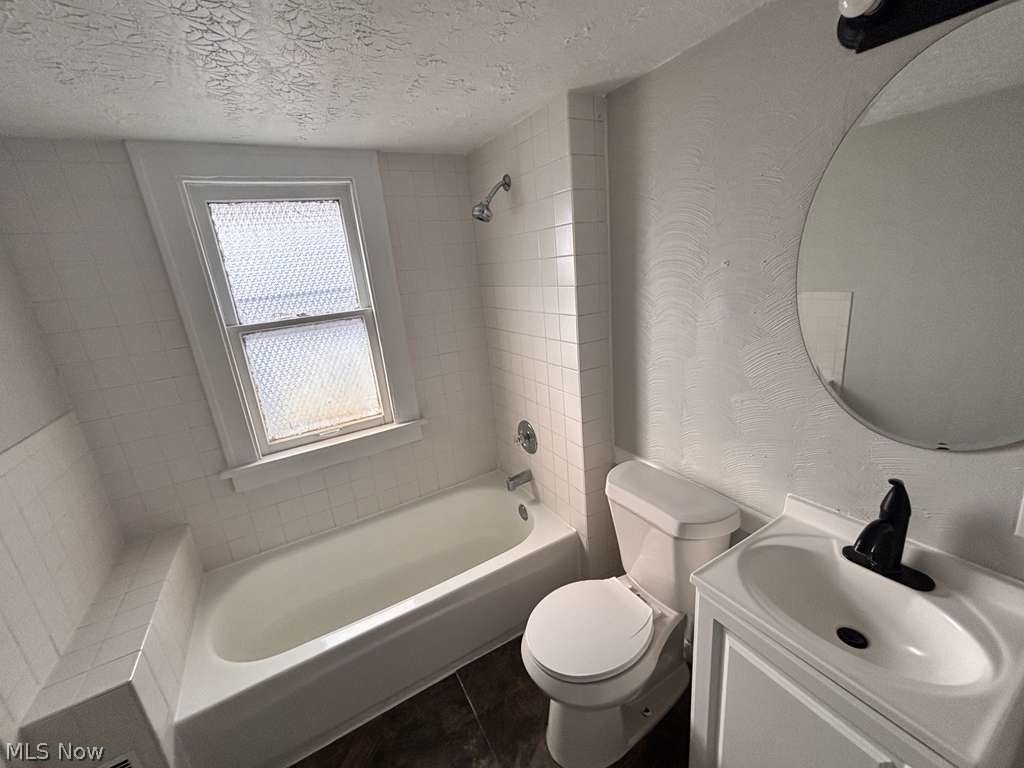 907 Rondel Road Cleveland, OH 44110 - Photo 18 of 26 Full bathroom featuring a white tub with shower, white tile surround, and an integrated tiled bench