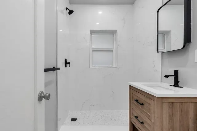 a bathroom with a shower sink and mirror