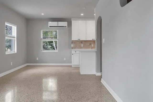 an empty room with a window and wooden floor