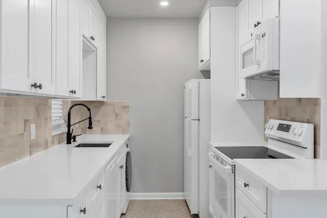 a kitchen with stainless steel appliances granite countertop white cabinets sink and white stainless steel appliances