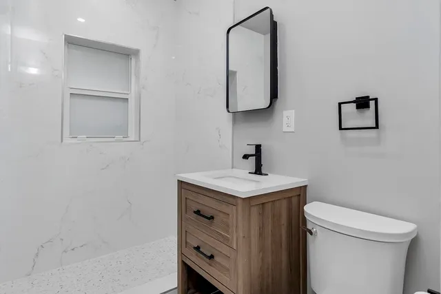 a bathroom with a toilet sink and mirror