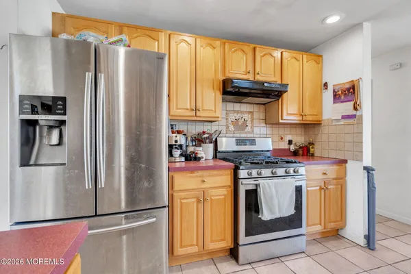a kitchen with stainless steel appliances granite countertop a refrigerator a stove and a sink