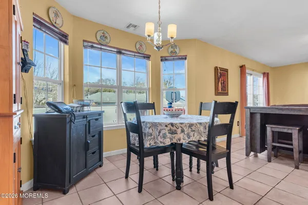 a view of a dining room with furniture a chandelier and window