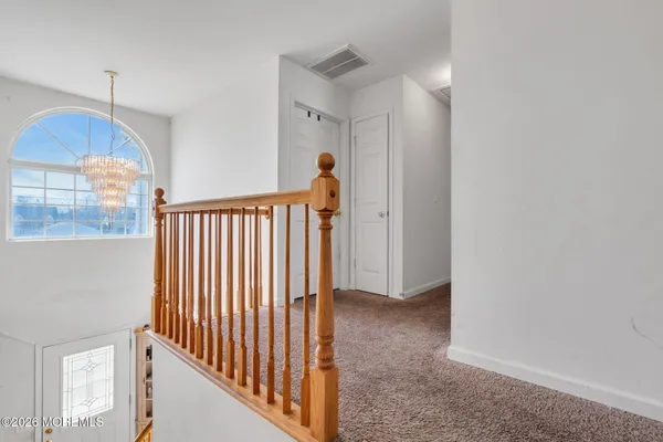 a view of a hallway with a window and stairs