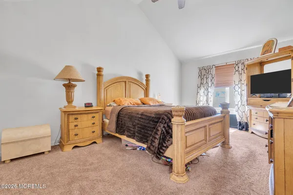 a bedroom with a bed and a flat tv screen on dresser