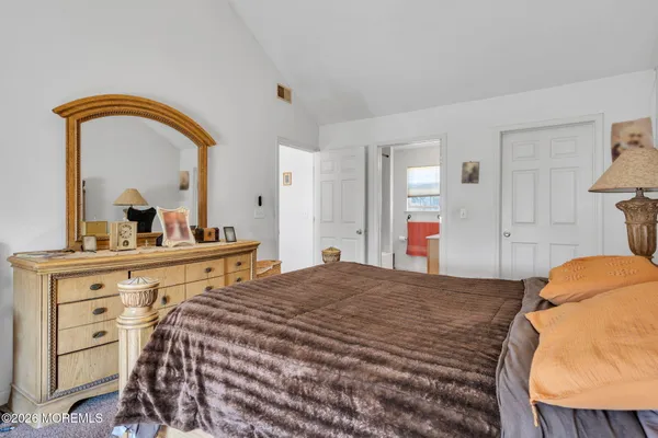a bedroom with a bed and a mirror on dresser