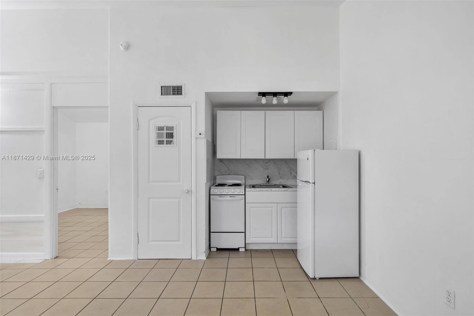 a kitchen with white cabinets and white appliances