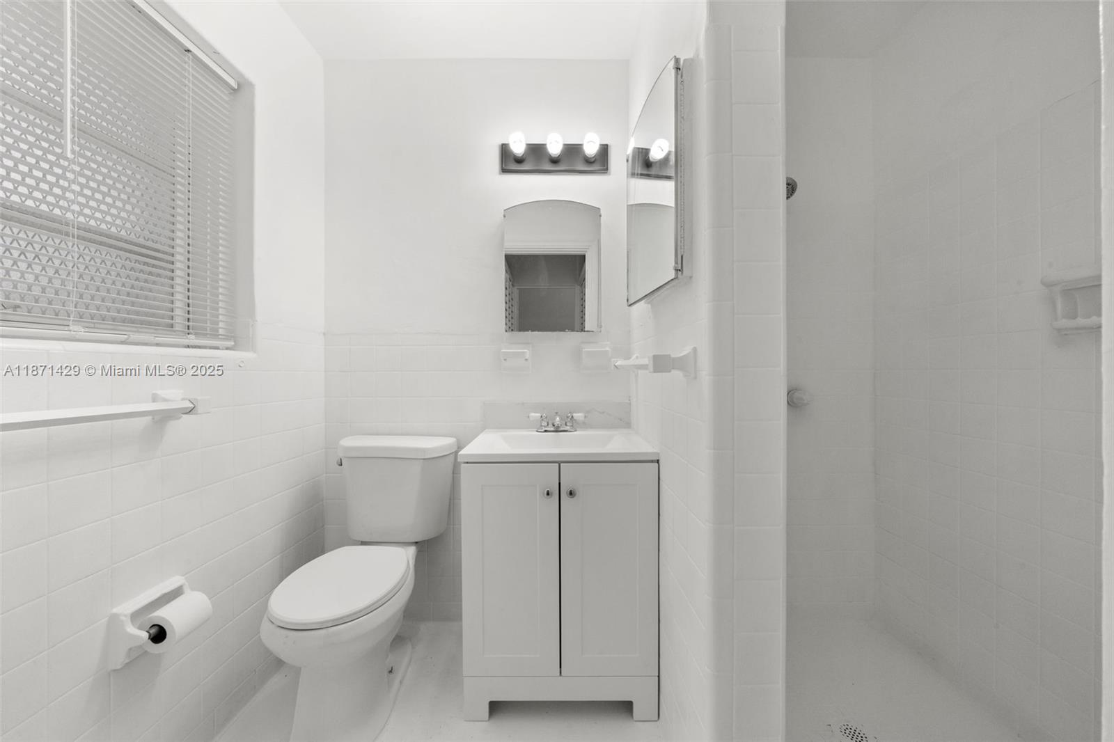 840 Southwest 7th Street, Unit 844 Miami, FL 33130 - Photo 8 of 10 a bathroom with a toilet a sink and mirror