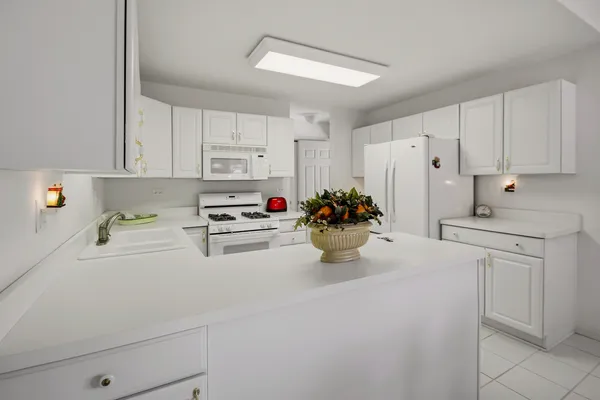 a kitchen with a white cabinets and white appliances