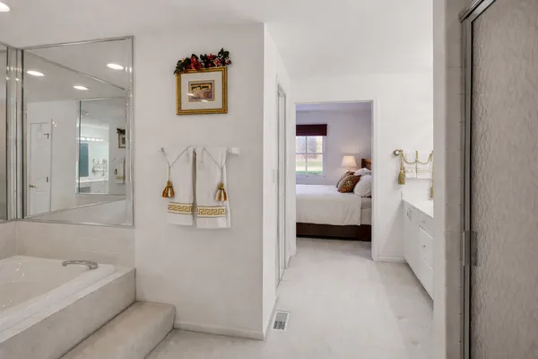 a en suite spacious bathroom with a tub sink and mirror