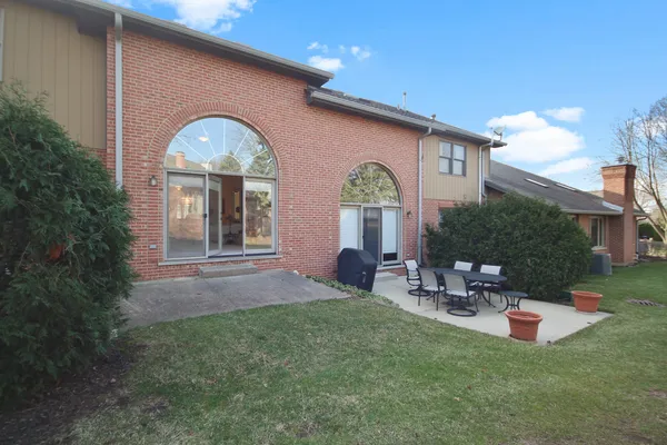 a backyard of a house with table and chairs