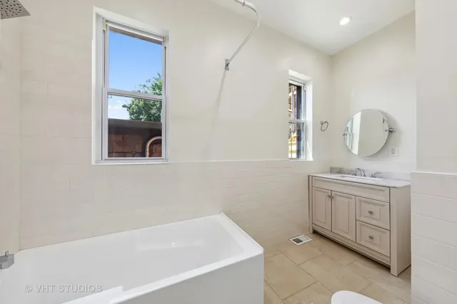 a bathroom with a granite countertop sink mirror and bathtub