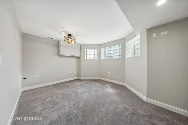an empty room with windows and cabinet