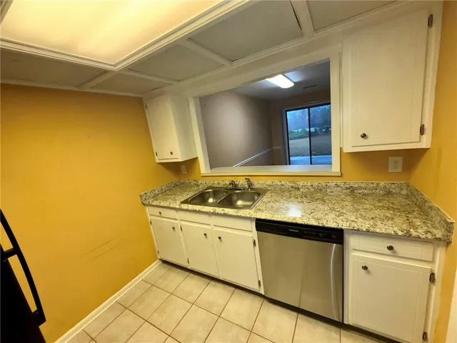a kitchen with stainless steel appliances granite countertop a sink and a stove next to a window