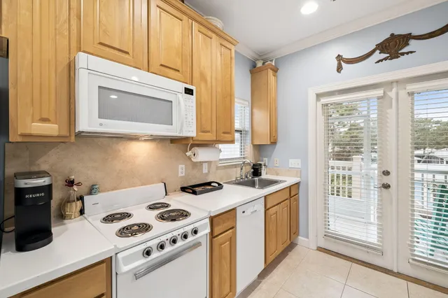 a living room with furniture a flat screen tv and kitchen view