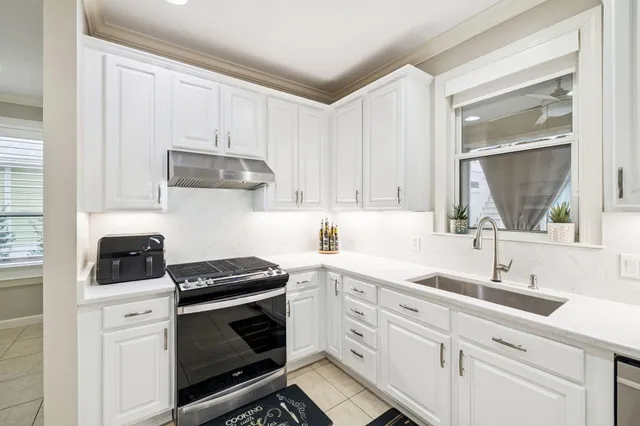 a kitchen with cabinets appliances a sink and a window