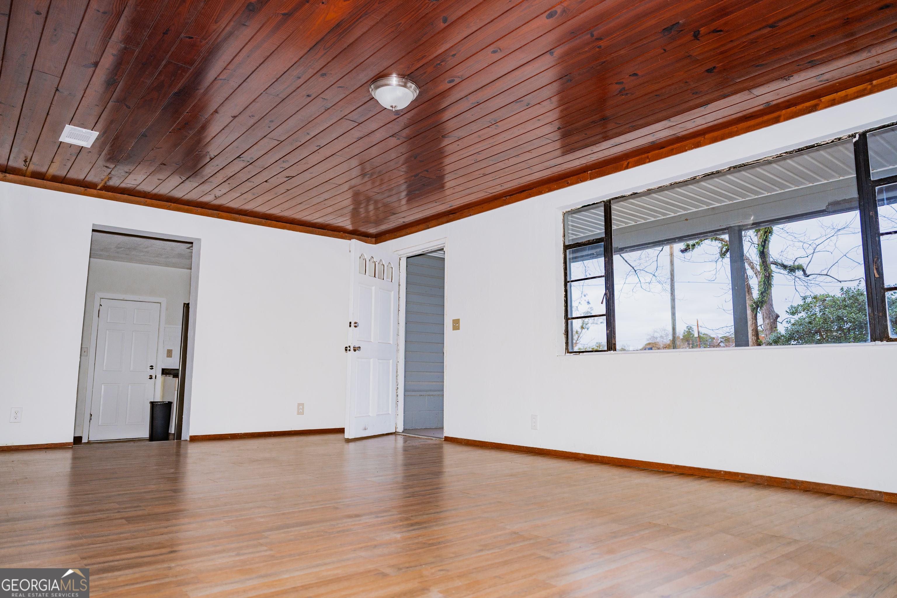 4427 Pine Valley Road Waycross, GA 31503 - Photo 11 of 24 a view of an empty room with wooden floor and a window