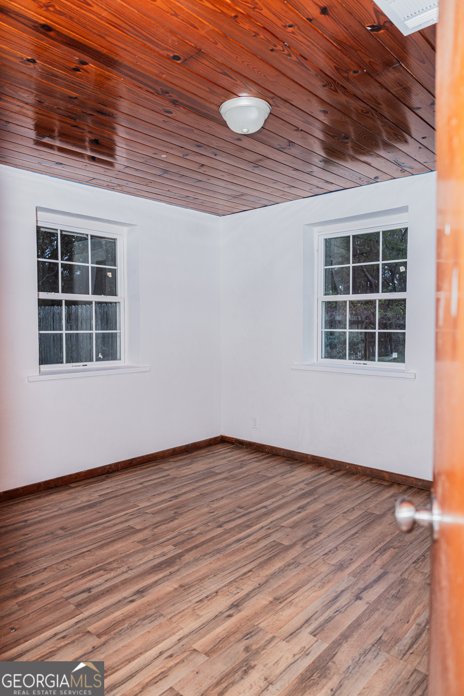 4427 Pine Valley Road Waycross, GA 31503 - Photo 19 of 24 a view of an empty room with wooden floor and windows