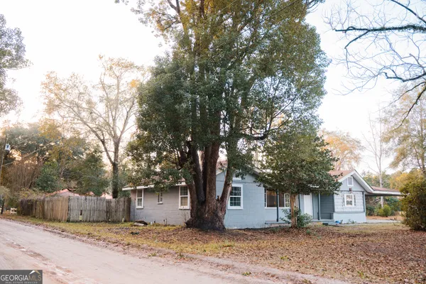 a front view of a house with a tree