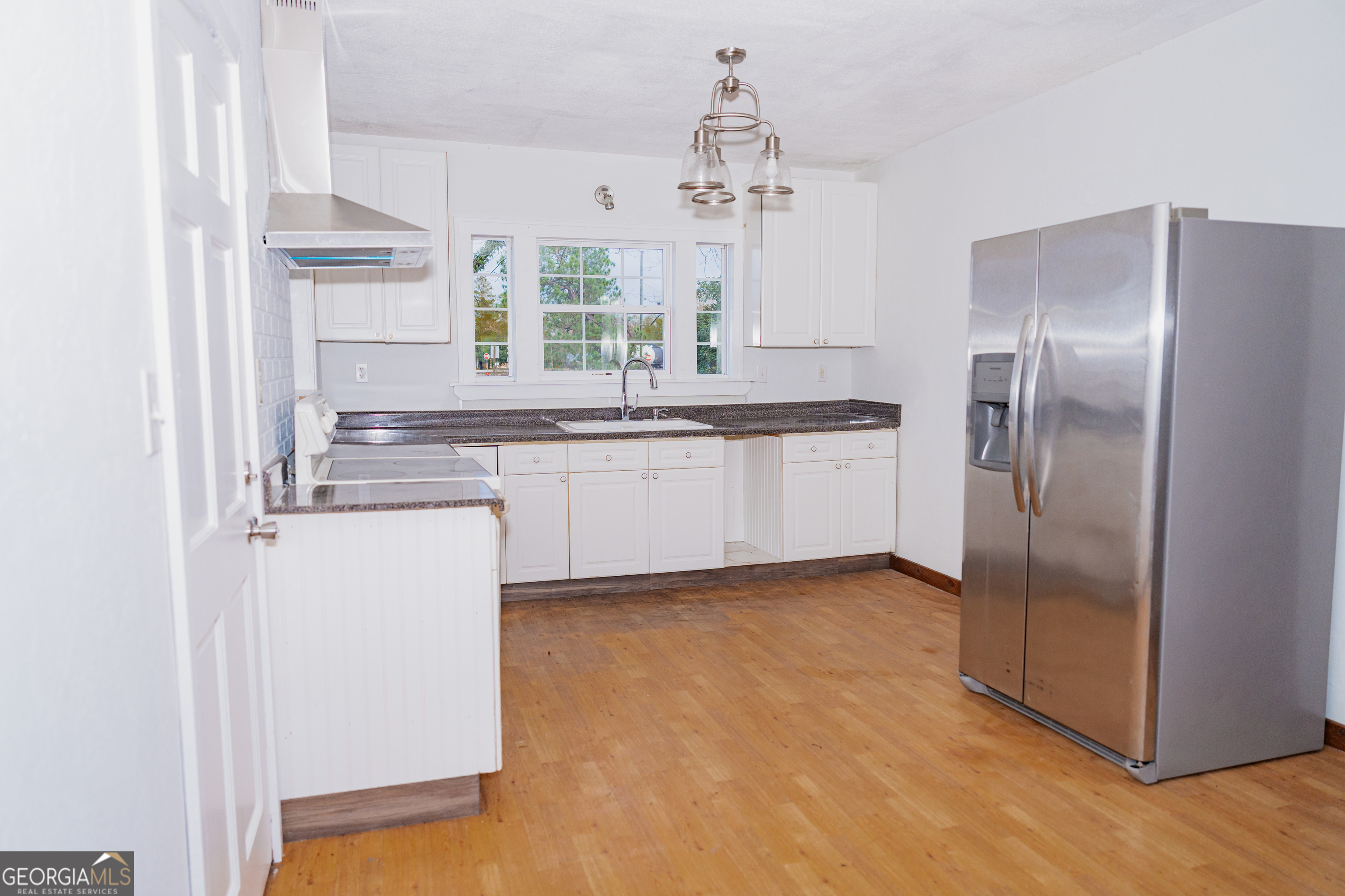 4427 Pine Valley Road Waycross, GA 31503 - Photo 8 of 24 a kitchen with granite countertop stainless steel appliances a sink and a refrigerator