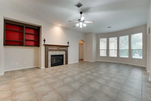 a view of an empty room with a fireplace and a window