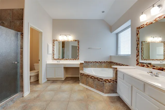 a bathroom with a tub sink and mirror