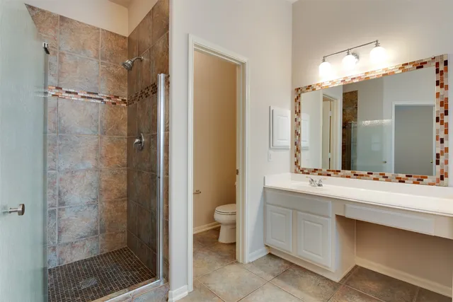 a bathroom with a double vanity sink toilet and shower