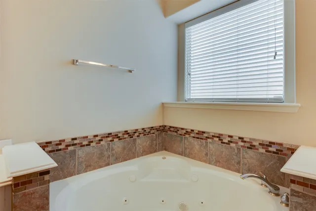 a bath tub sitting in a bathroom next to a window