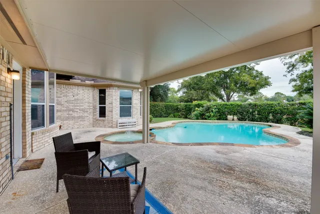 a view of backyard with swimming pool and outdoor seating