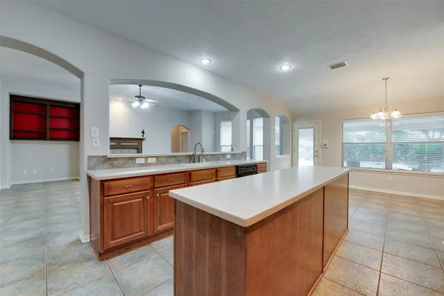 a large kitchen with kitchen island a sink a counter space and appliances