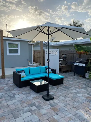 a backyard of a house with barbeque oven table and chairs