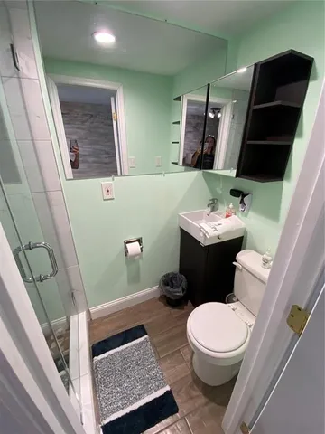 a bathroom with a granite countertop sink a toilet and shower
