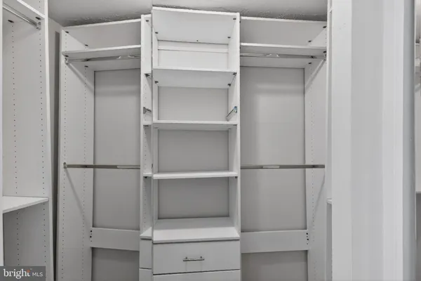 a view of walk in closet with empty racks