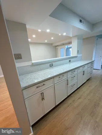 a bathroom with a granite countertop sink and a large mirror