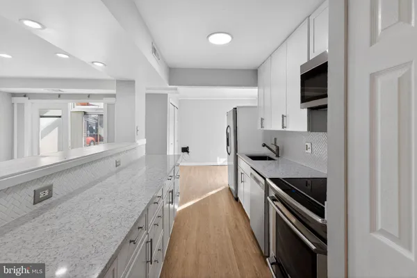 a kitchen with stainless steel appliances a stove sink and cabinets