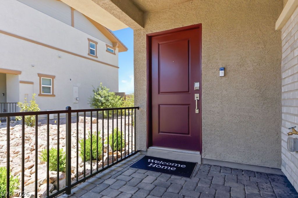 913 Cadence View Way Henderson, NV 89011 - Photo 9 of 46 A welcoming entry invites with a rich-toned door and paved porch, flanked by an attractive rock garden.