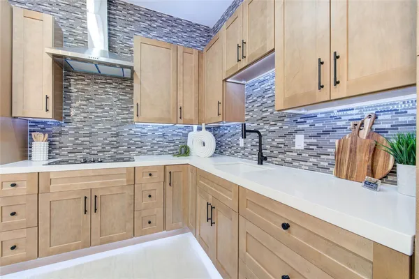 a kitchen with white cabinets and sink