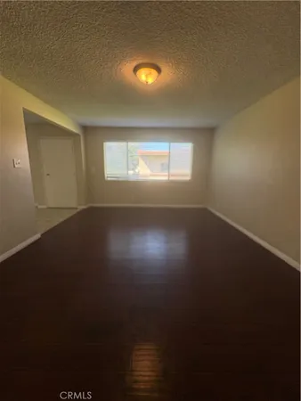 a view of room and hall with wooden floor