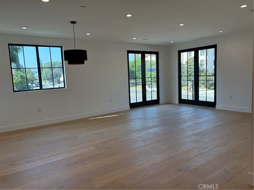 10352 Riverside Drive, Unit 201 Toluca Lake, CA 91602 - Photo 11 of 49 an empty room with wooden floor and windows