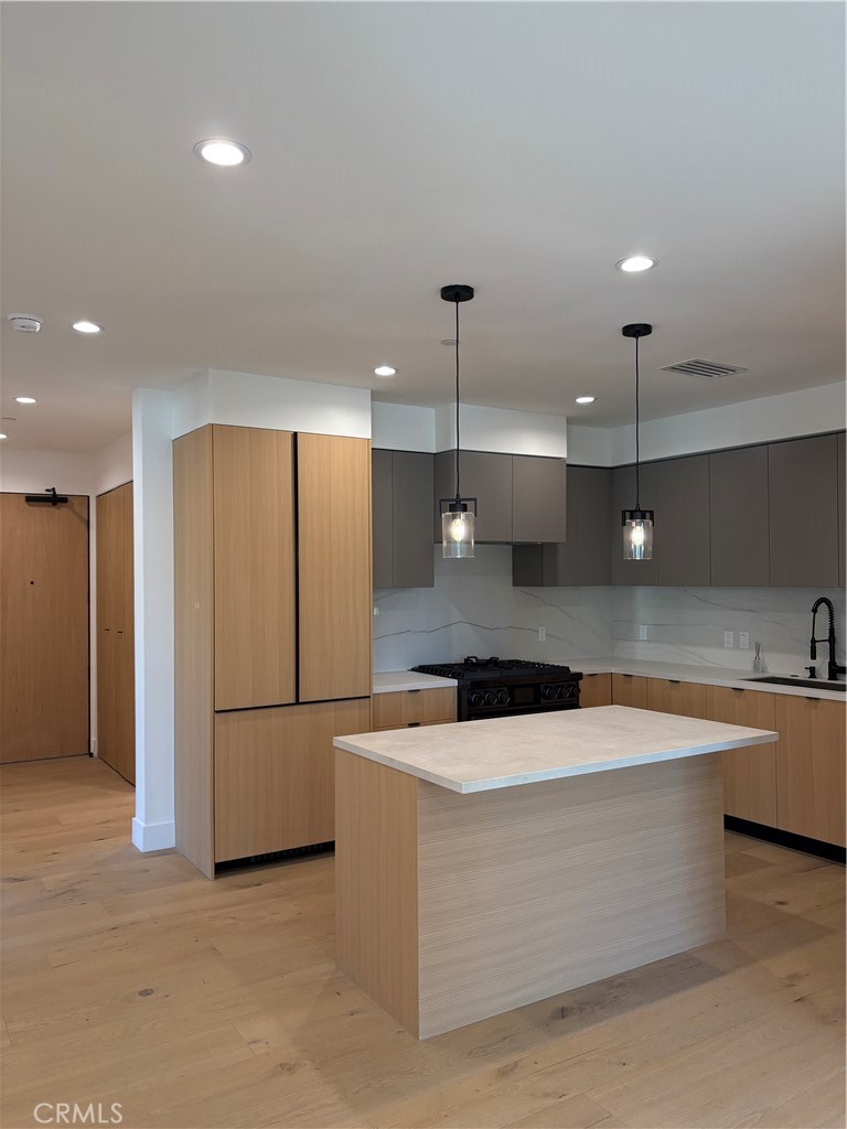 10352 Riverside Drive, Unit 201 Toluca Lake, CA 91602 - Photo 13 of 49 a large kitchen with stainless steel appliances a large counter top a large island in it