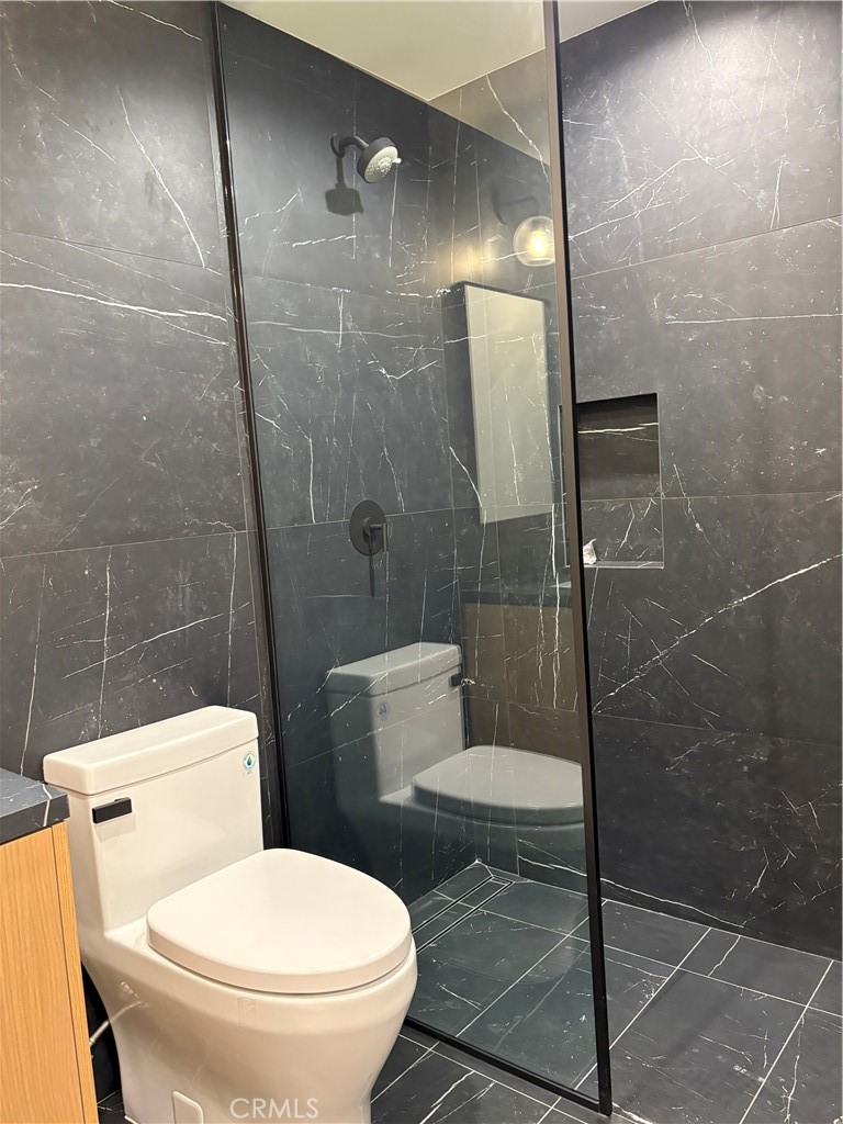 10352 Riverside Drive, Unit 201 Toluca Lake, CA 91602 - Photo 23 of 49 a white toilet sitting next to a bathroom sink and a shower