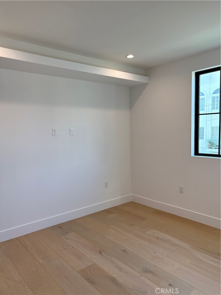 10352 Riverside Drive, Unit 201 Toluca Lake, CA 91602 - Photo 24 of 49 a view of an empty room with wooden floor and a window