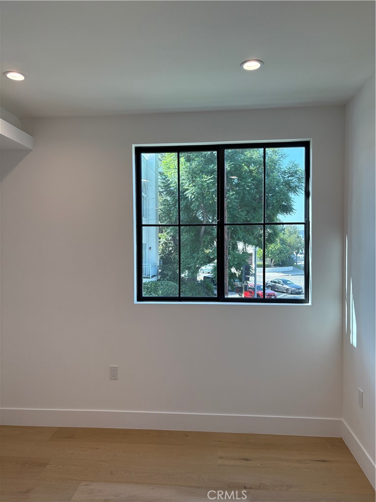 10352 Riverside Drive, Unit 201 Toluca Lake, CA 91602 - Photo 25 of 49 an empty room with wooden floor and windows
