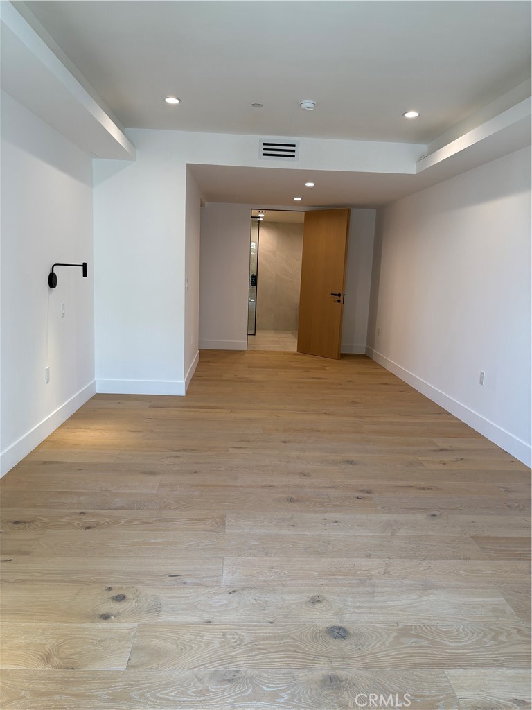 10352 Riverside Drive, Unit 201 Toluca Lake, CA 91602 - Photo 31 of 49 an empty room with wooden floor and natural light