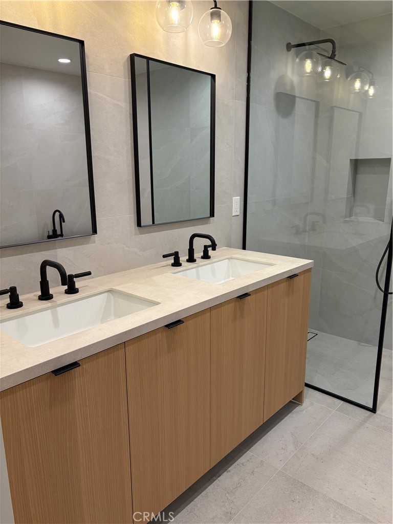 10352 Riverside Drive, Unit 201 Toluca Lake, CA 91602 - Photo 32 of 49 a bathroom with a double vanity sink and a mirror