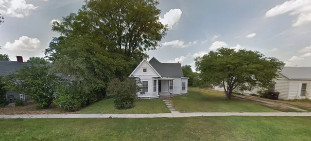 a front view of a house with a garden and yard