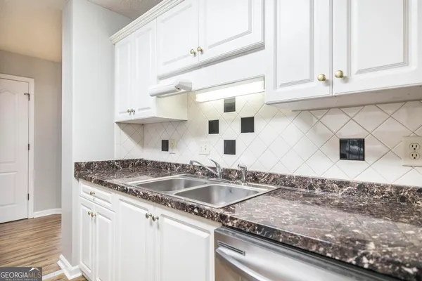 a kitchen with granite countertop a sink and a stove